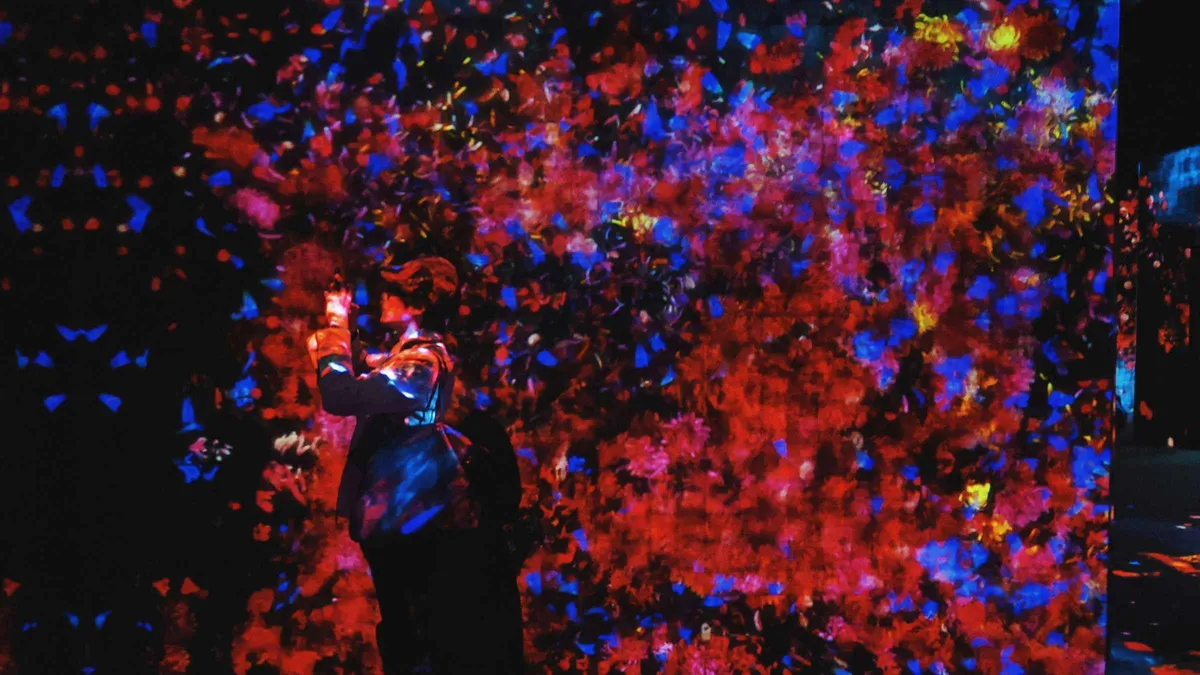 Visitors surrounded by projected light in the teamLab Borderless digital art museum at Azabudai Hills, Tokyo